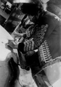 HENDRIX, JIMI - Black and white photograph of Hendrix re-stringing his guitar at... Black and