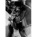HENDRIX, JIMI - Black and white photograph of Hendrix re-stringing his guitar at... Black and