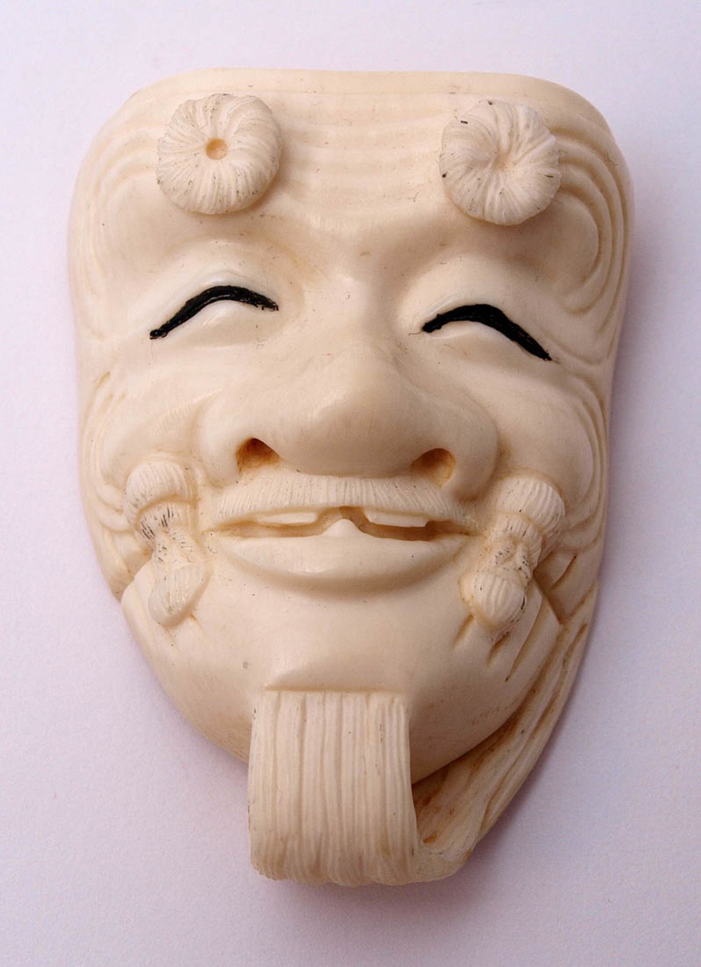 Netsuke In Form einer lachenden Maske. Verso sign. Elfenbein. H.5cm.    Aufrufpreis: 150 EUR