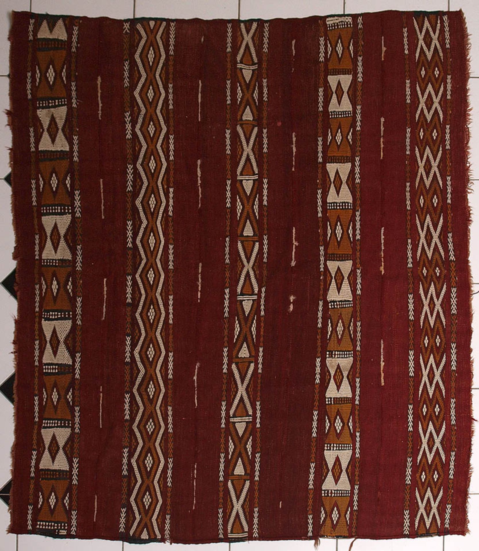 KelimRotgrundig, mit zweifarbigen Zacken- und Rautenbändern. 145x167cm.Aufrufpreis: 80 EUR