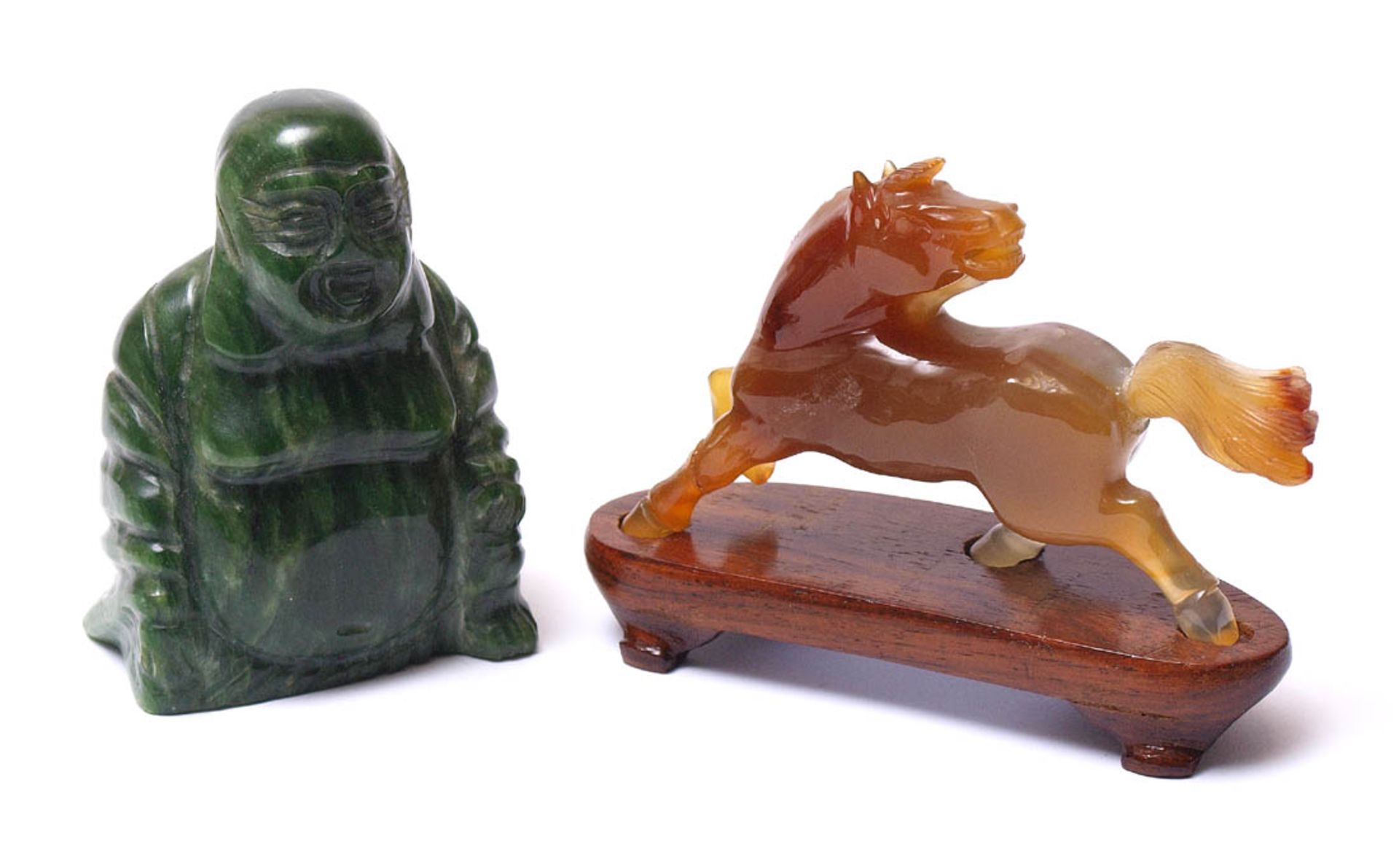 BuddhafigurGrüne Jade (?). H.8cm. Dazu Pferd aus geschnittenem rotbraunem Achat. L.9,5cm. Linker