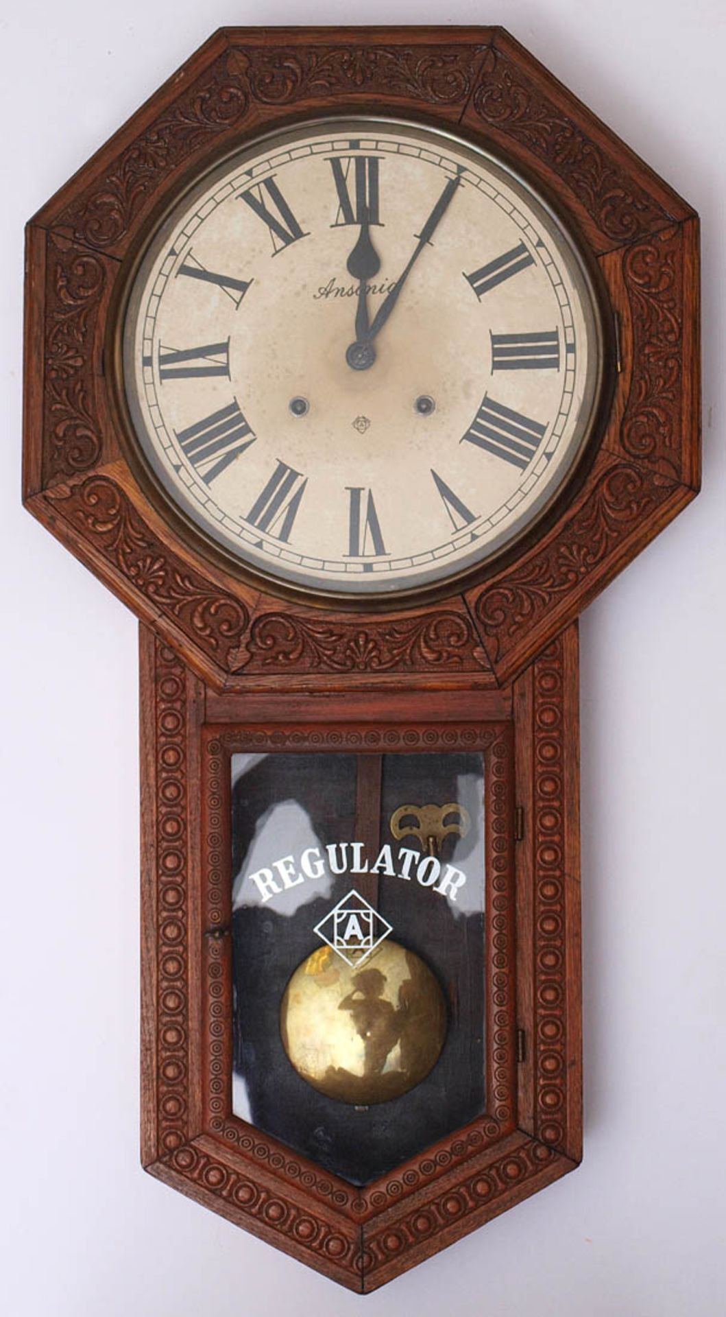 Regulator, USAAchteckiges Gehäuse aus geschnitztem Holz mit verglastem Pendelfach. Metallzifferblatt