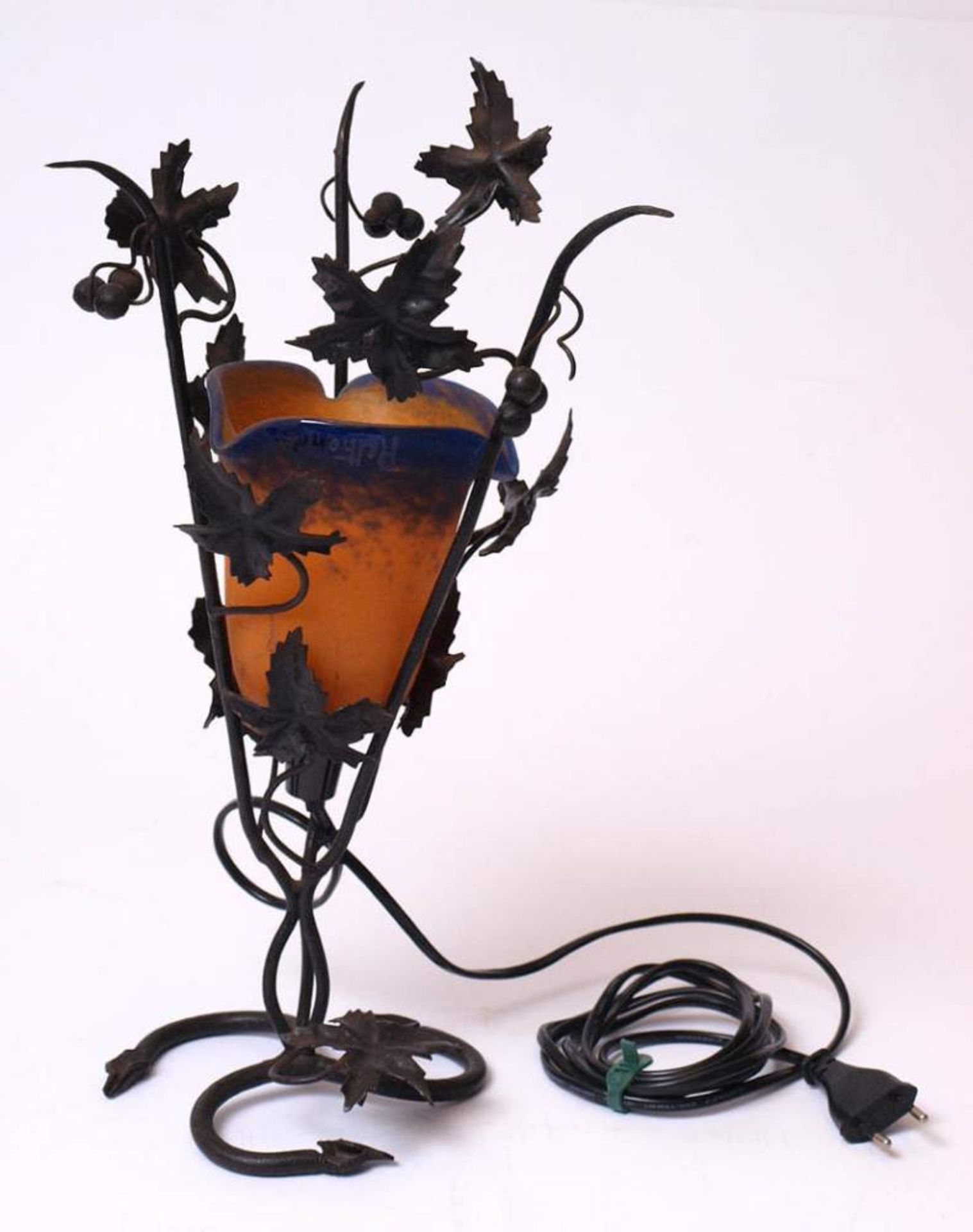 Tischlampe, um 1910Vegitabiles Eisengestell mit Blattwerk und Früchten. Glockenförmiger Schirm mit