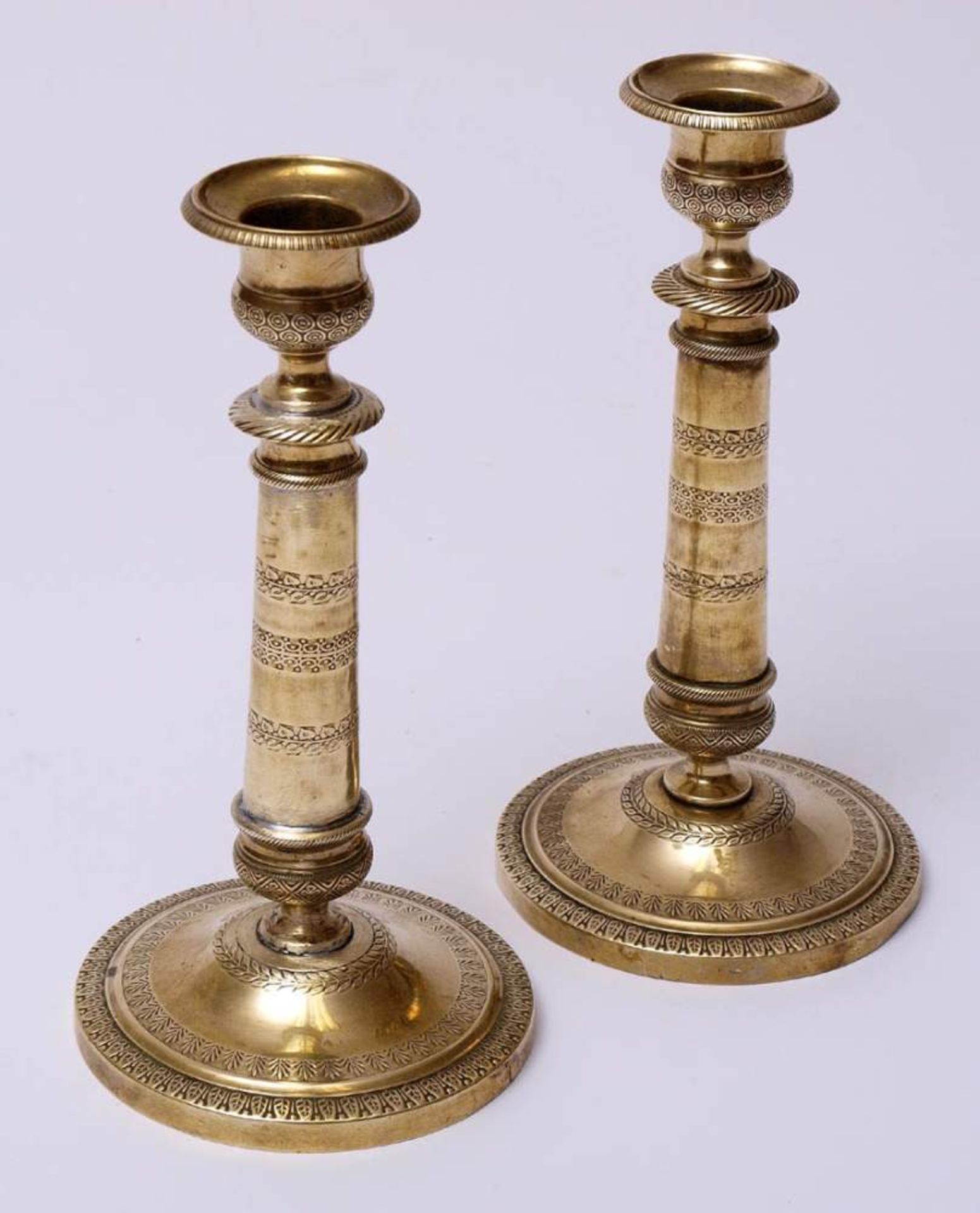 Paar Tafelleuchter, um 1810Auf rundem Standfuß mit reliefierten Lorbeergirlanden, Palmetten und