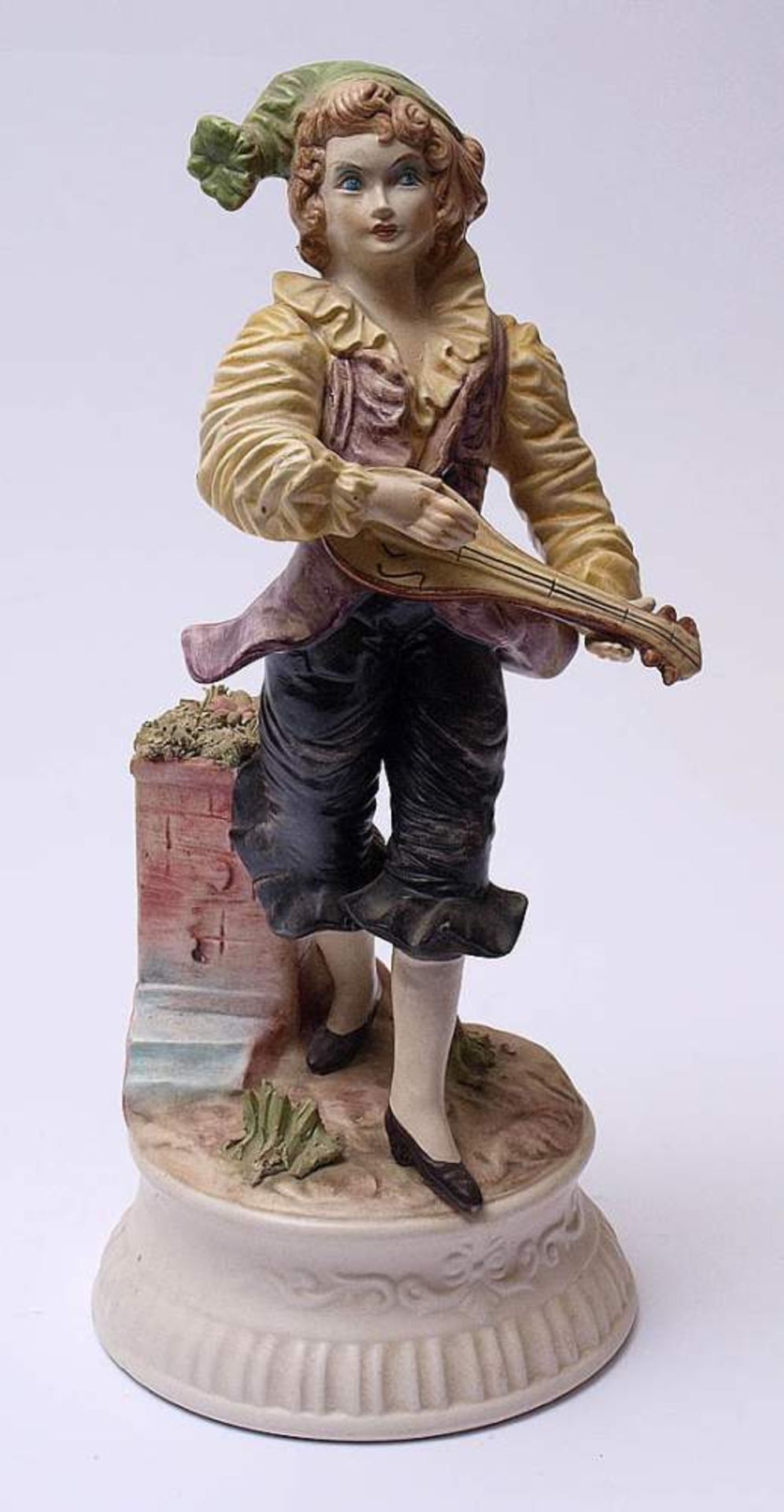 FigurineAuf reliefiertem Sockel Mandoline spielender junger Mann. Polyhcrom bemalt. H.40cm.