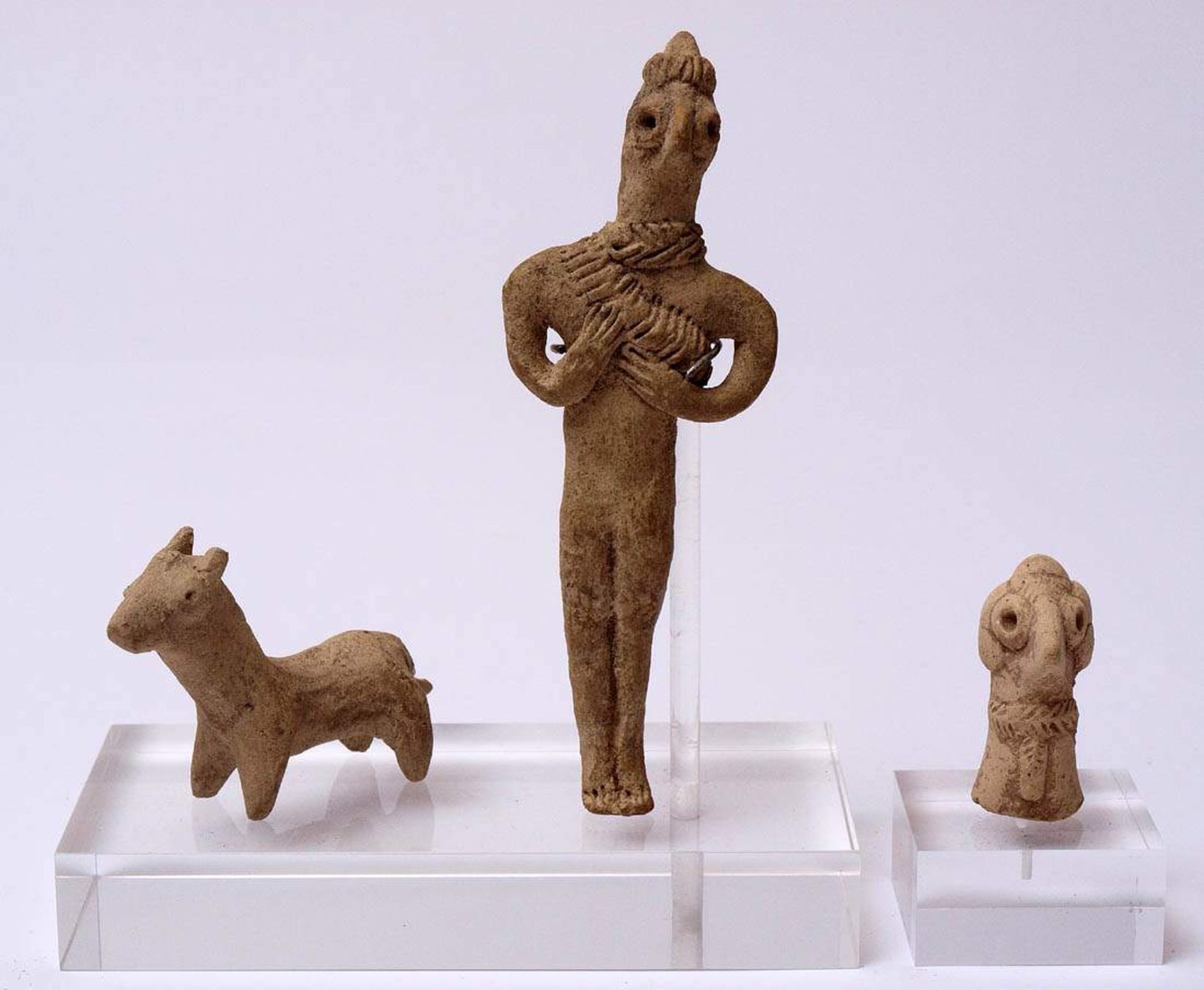 Syro-hethitisches Idol mit Hund, wohl frühes 2. Jahrtausend v.Chr.Weißer Ton. H.12,5cm bzw. 7x4,6cm.