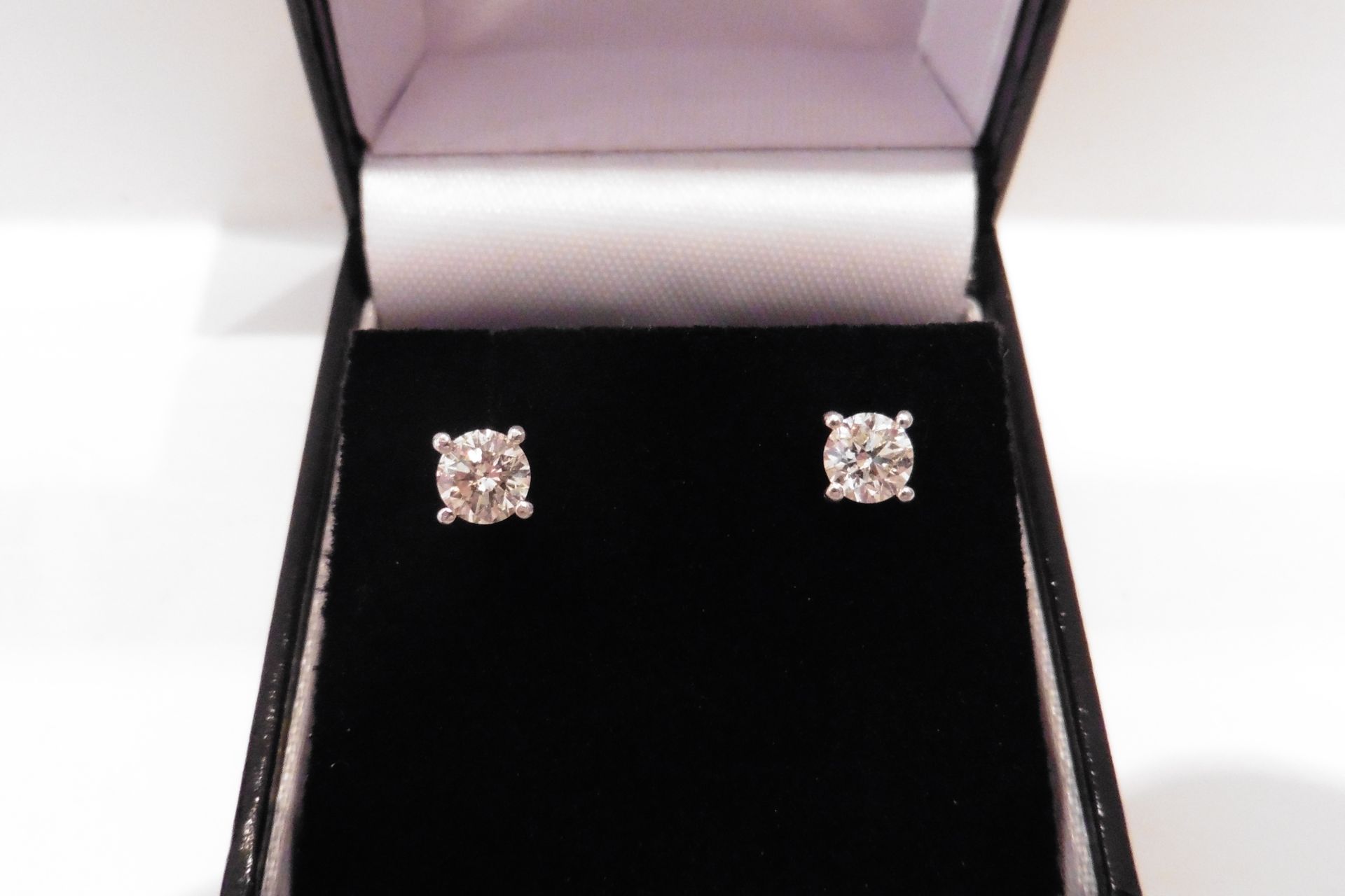 Elegant pair of solitaire stud earrings each set with a russian cut diamond weighing a total of 0.40