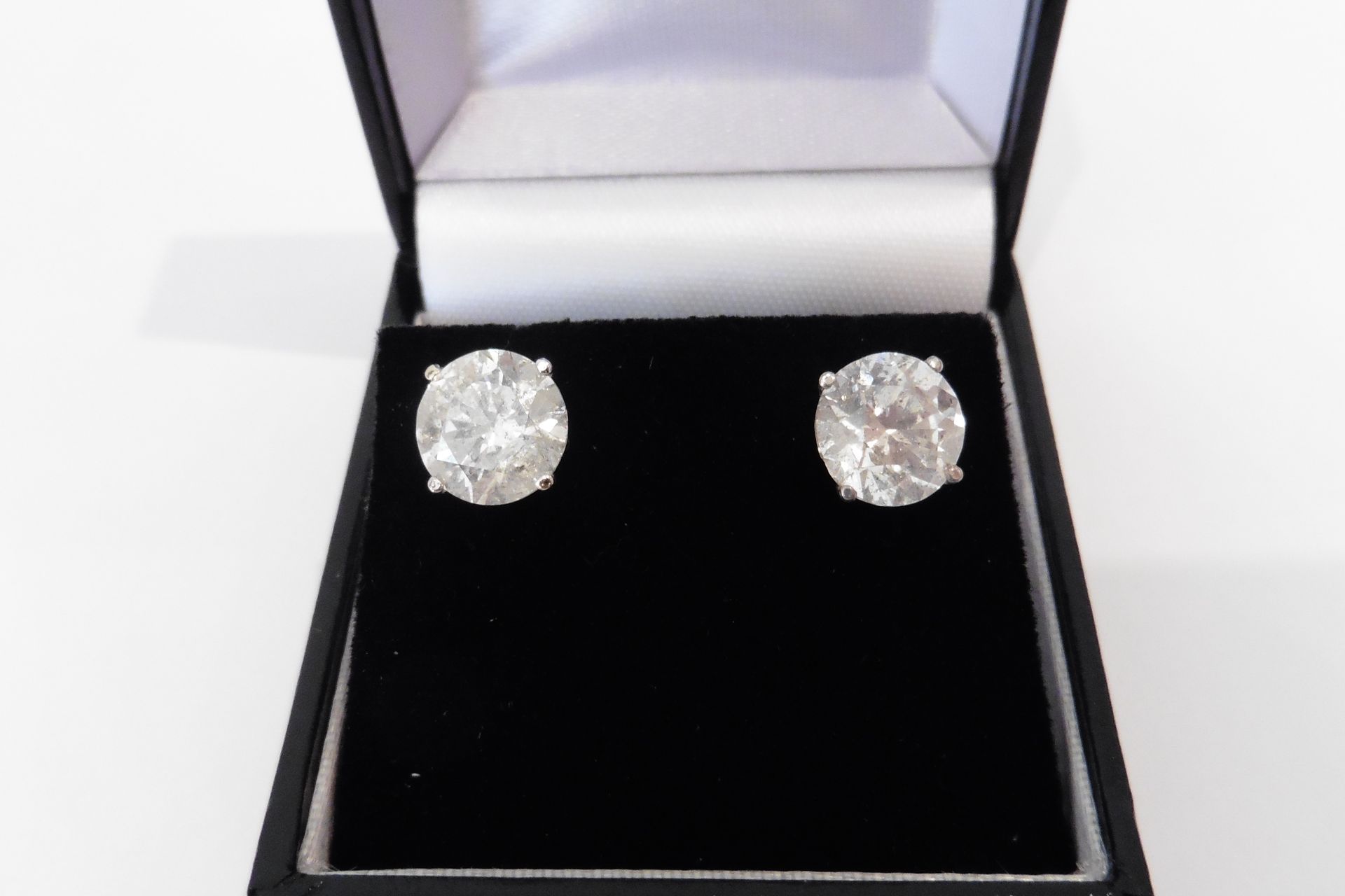 Stunning and elegant pair of diamond solitaire style earrings each set with a brilliant cut diamond,