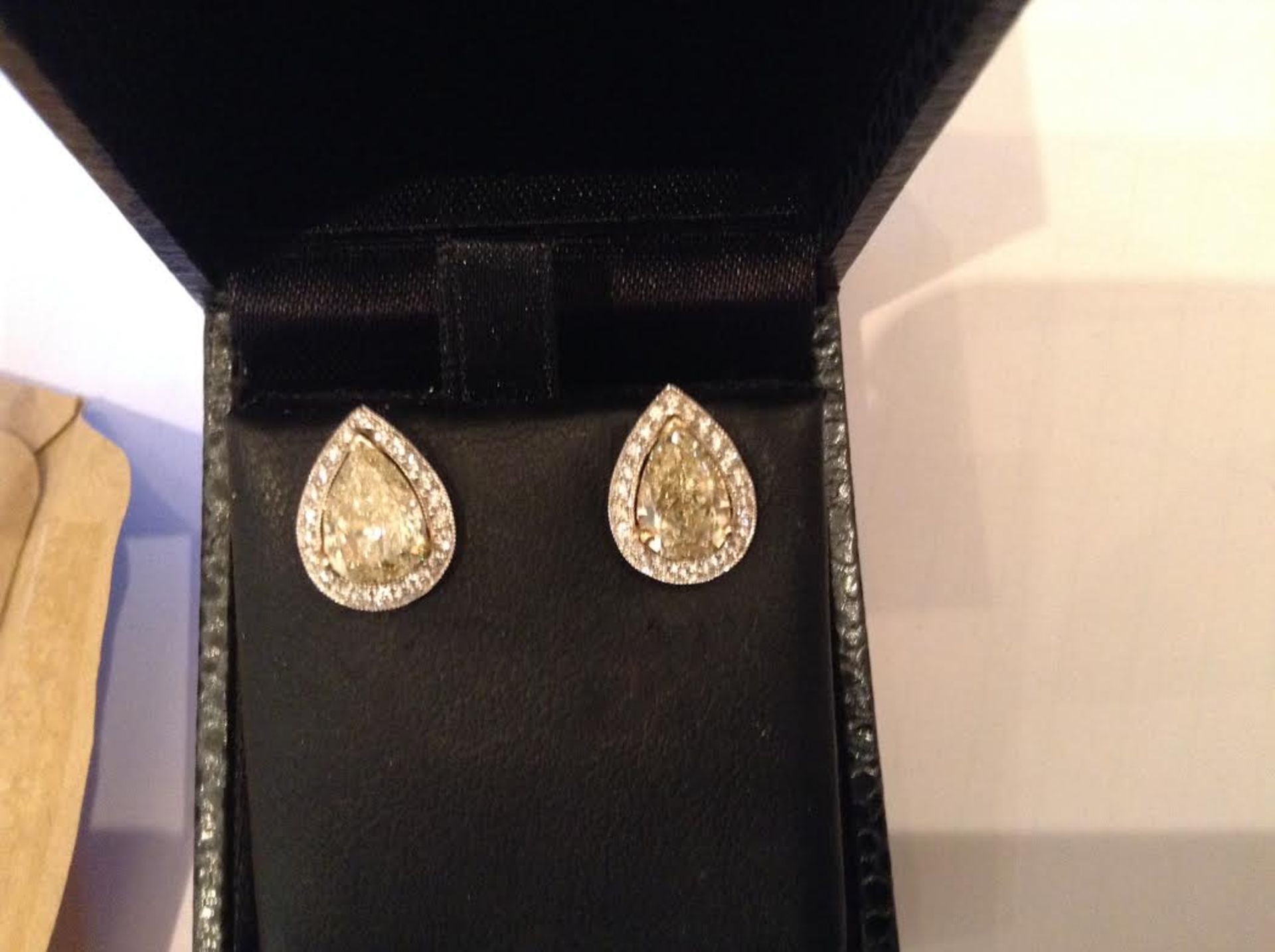 Tiffany style diamond stud earrings each set with a fancy yellow pear shaped diamond weighing 1.00ct