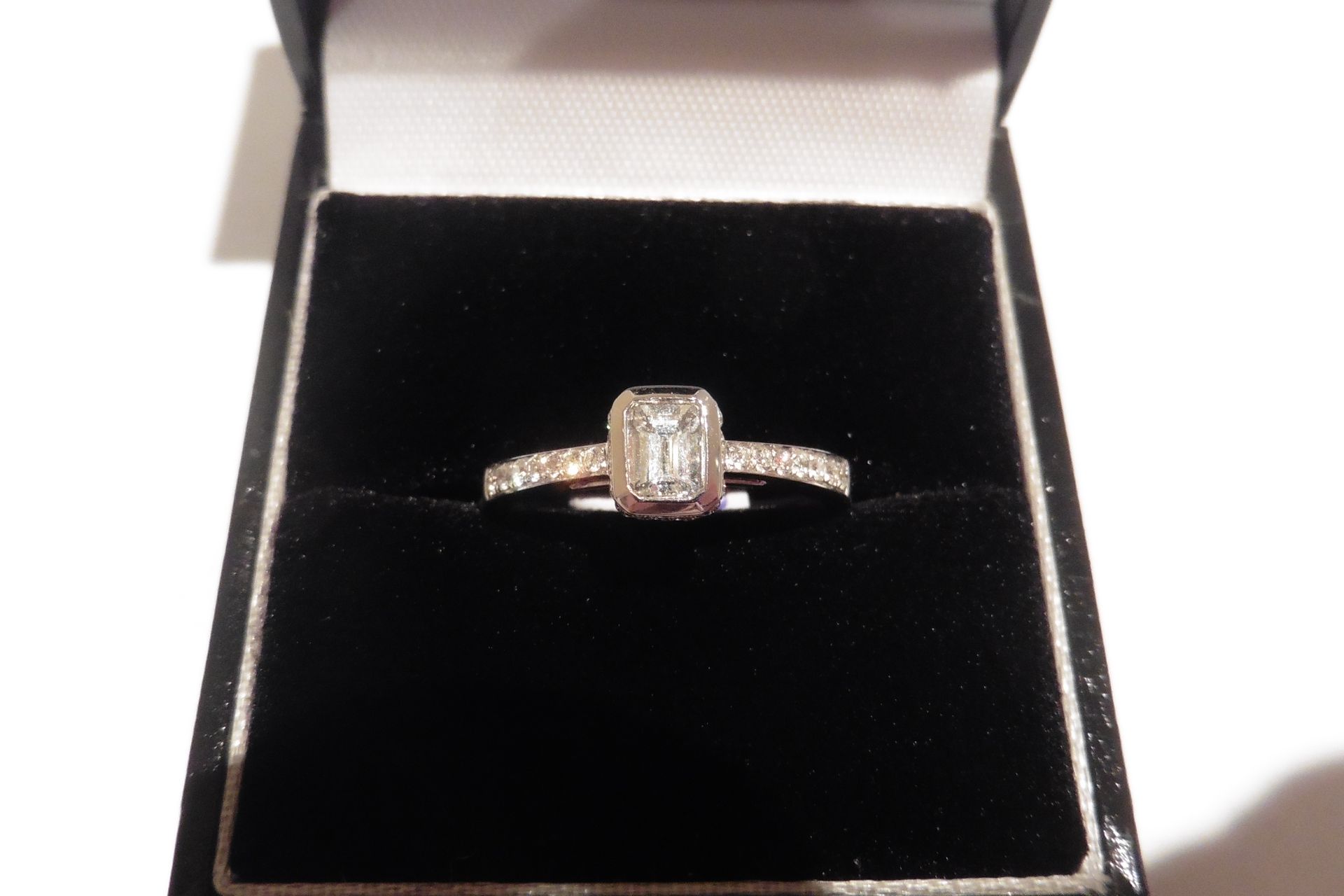 18ct white gold diamond ring with a VS clarity emerald cut diamond, weighing 0.50ct surrounded in a