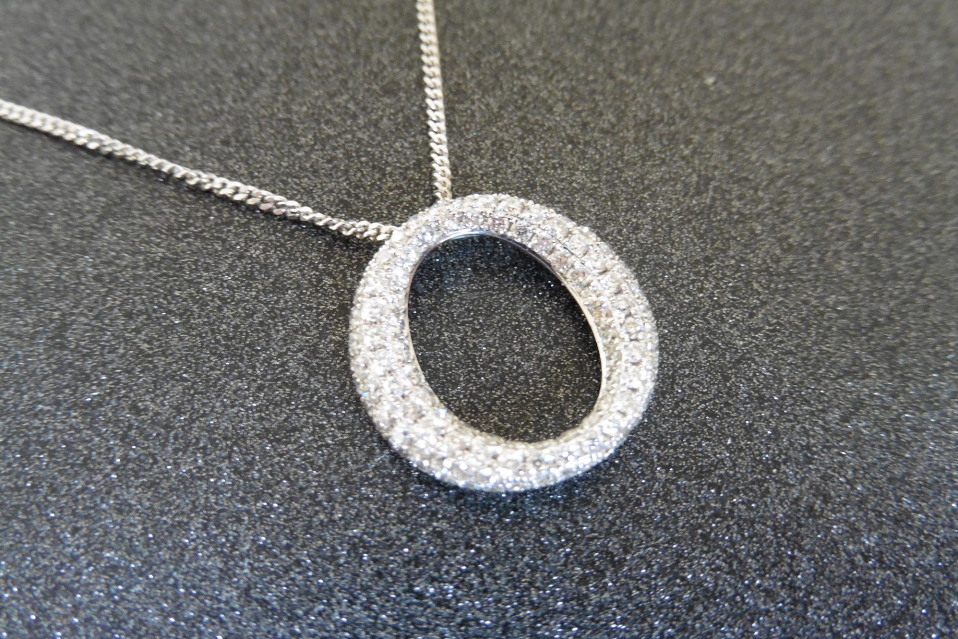 18ct white gold diamond set pendant in an 'o' design.  Set with tiny brilliant cut diamonds weighing