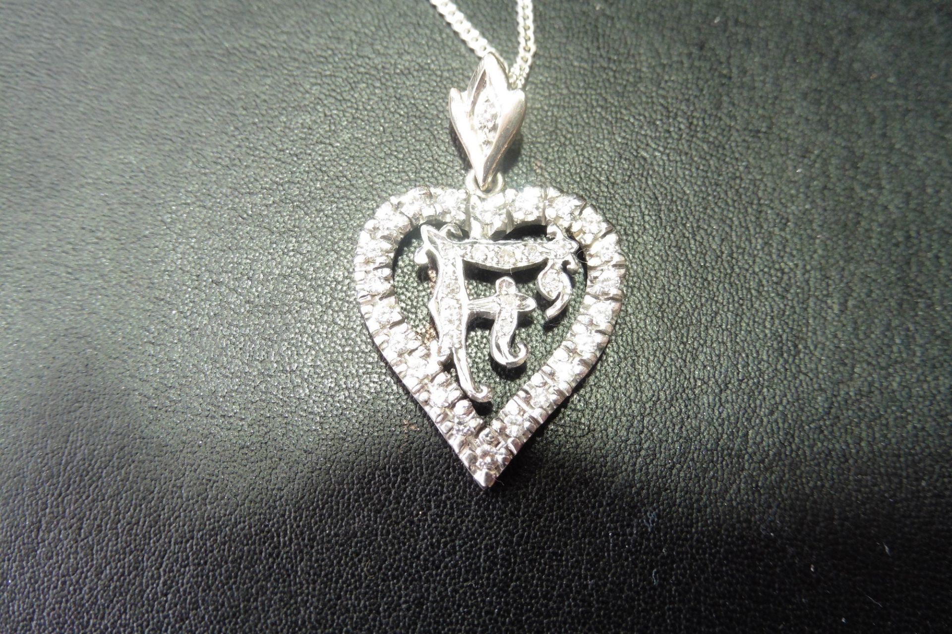 Pre-owned white gold diamond set heart pendant with the initial F inside.  The heart is diamond set