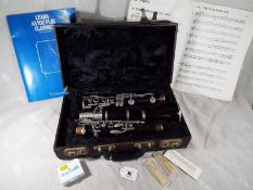 A Boosey & Hawkes of London clarinet, The Edgware, with hard case, reeds, sheet music,