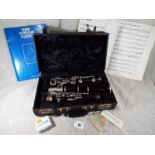 A Boosey & Hawkes of London clarinet, The Edgware, with hard case, reeds, sheet music,