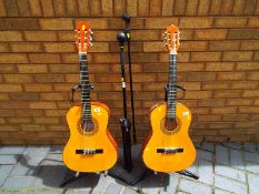 Two classical guitars one with soft carry case,