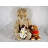A straw filled teddy bear with jointed limbs, glass eyes, stitched nose and growler,