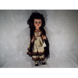 A vintage dressed doll with jointed limbs, with sleeping eyes, marked to the back of the body D.I.L.