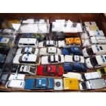 Approximately 36 diecast model emergency vehicles, predominantly Police with some ambulance,