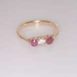 Three stone ladies dress ring on an 18ct yellow gold shank, inset diamond and 2 rubies, stamped 18ct
