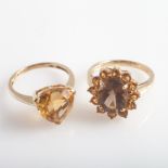 Two 9ct yellow gold citrine set dress rings, one set with triangular stone, the other an oval.