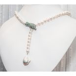 Cultured pearl necklace with unusual silver and emerald snake design clasp