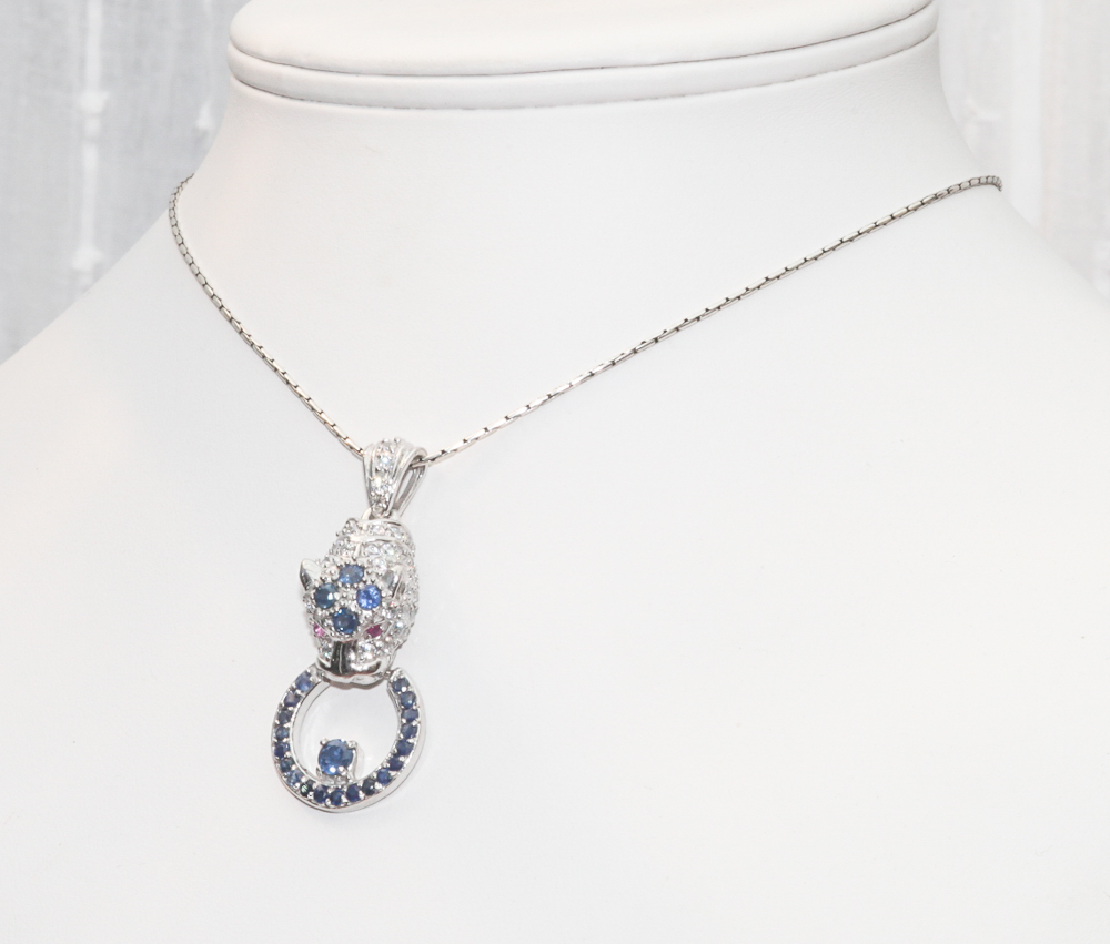 Silver pendant necklace modelled as leopard holding a ring set with sapphires and rubies