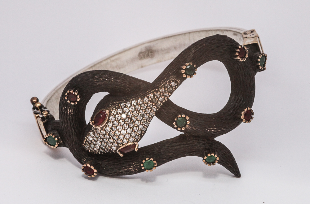 Ladies hinged bangle of a snake design with inset paste.