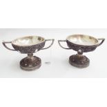 Pair of silver plated twin handled urns on weighted bases 10cm tall