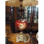 Red and floral decorated table lamp on metal rose patterned base with cream shade