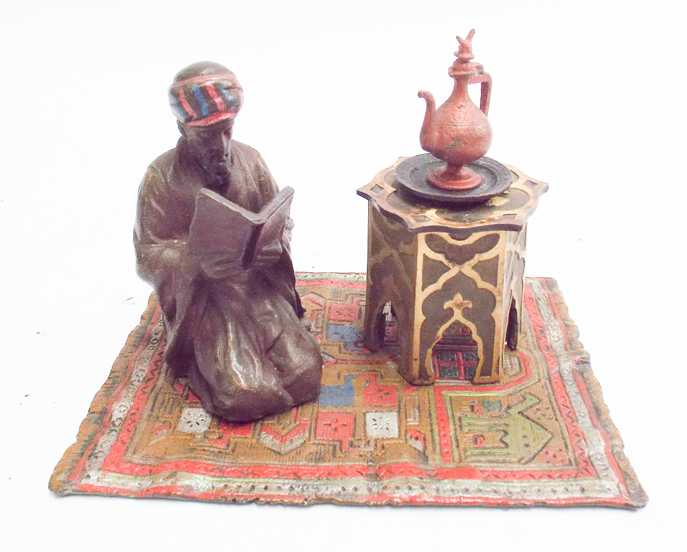 Cold painted bronze model of Arab street vendor on a carpet with coffee pot,