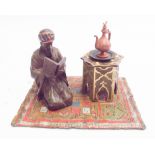 Cold painted bronze model of Arab street vendor on a carpet with coffee pot,