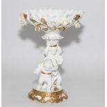 Falon China centre comport, cream glazed with cherub figure support, encrusted rose decoration,