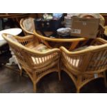 Circular bamboo conservatory table with glass top and four matching elbow chairs with floral