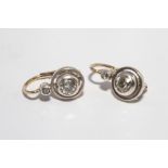 Pair of antique diamond earrings in rub over settings, pierced wire fittings.