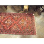 An Afghan red patterned wool pile runner (approx 9' x 2' 6")