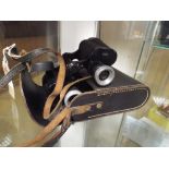 Pair of old black painted binoculars with leather case (a/f)  As found