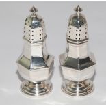 Pair of hallmarked silver octagonal bodied pepper pots,