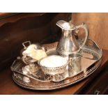 Oval two handled plated tray with pierced borders, water jug, sugar scuttle, sugar bowl,