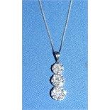 An 18ct white gold and diamond pendant, in the form of three flowerheads, on an 18ct white gold