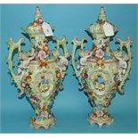 A pair of Continental porcelain vases, applied putti, with painted and  applied floral decoration (