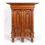A Continental oak armoire, the large projecting cornice above a pair of panel doors carved face