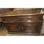 An oak dresser base, having two frieze drawers above a pair of panel doors, on bun feet, 130 cm wide