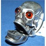 A silver vesta, in the form of a skull, with glass eyes