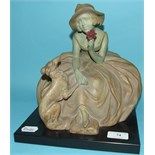 An Art Deco Belgian pottery figure, of a seated lady with a dog, 23.5 cm high