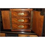 A walnut tabletop cabinet, with two panel doors revealing three drawers, 30 cm wide