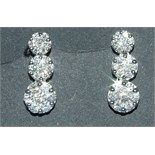 A pair of 18ct white gold and diamond drop earrings, in the form of three flowerheads