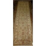 A Persian runner, with stylised floral motifs on a cream ground, within a multi-border, 310 x 81 cm