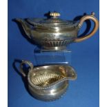 An early 19th century silver teapot, of compressed circular form, with a reeded lower body,
