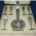 A glass and silver coloured metal mounted liqueur set, comprising a decanter and six glasses (a.f.