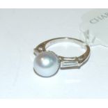 A platinum ring, set a pearl flanked by